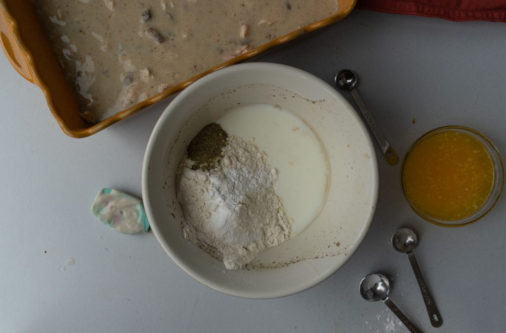 crust ingredients in a bowl with chicken and gravy in casserole dish in the top of the photo