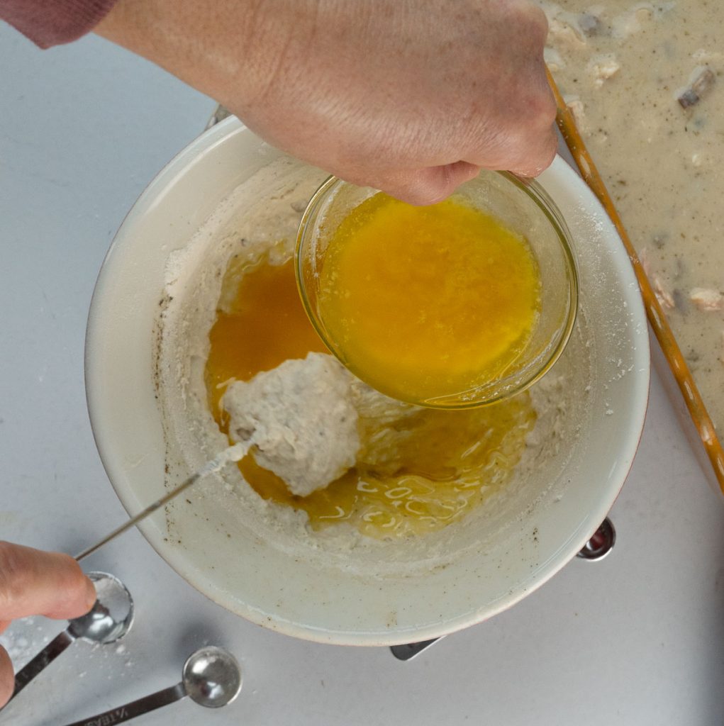 Adding melted butter to the crust ingredients. 