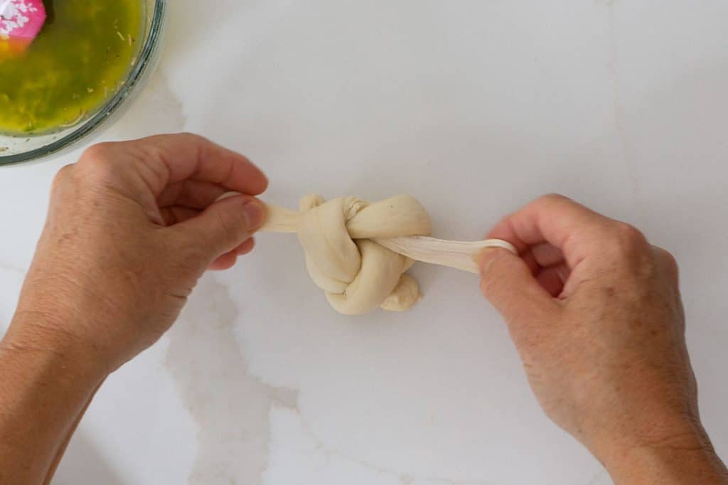 tying the second knot in the garlic roll