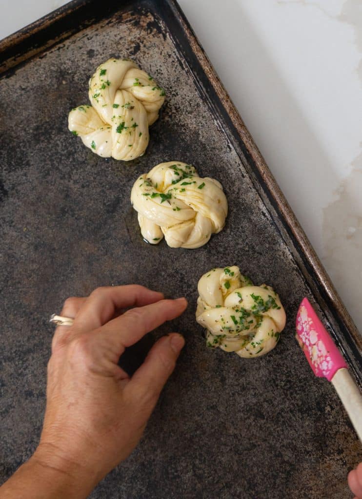 placing garlic knot on baking sheet
