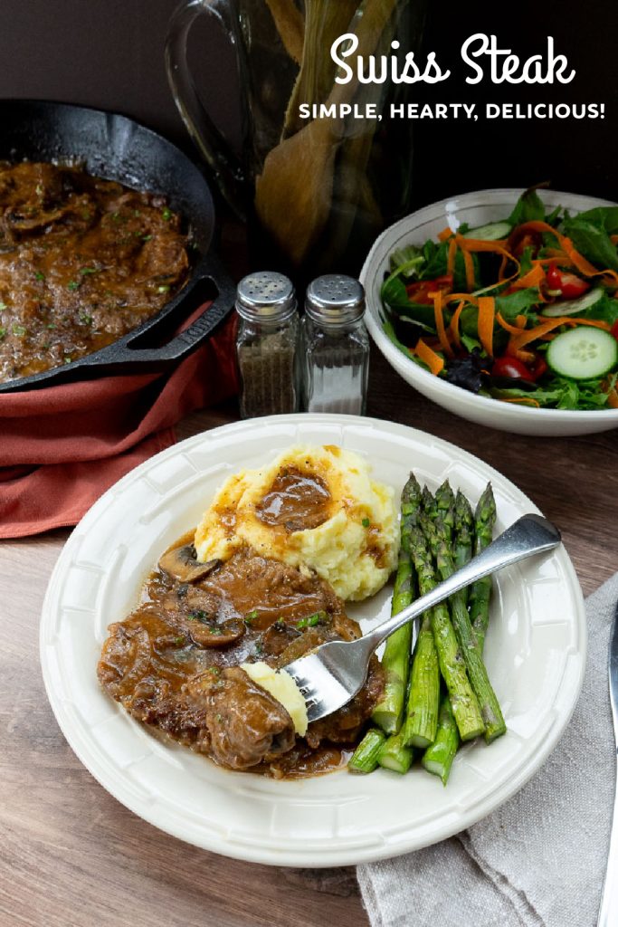 swiss steak on a plate with mashed potatoes and asparagus