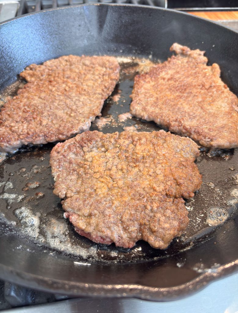 frying steaks dredged in flour in butter in a cast iron skillet