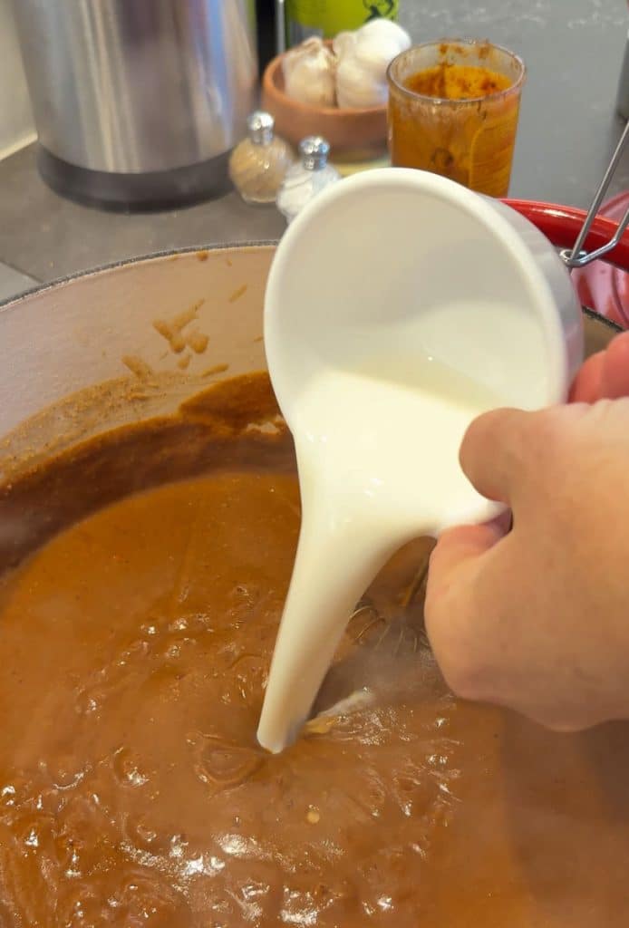 Adding milk to the wet burrito red sauce