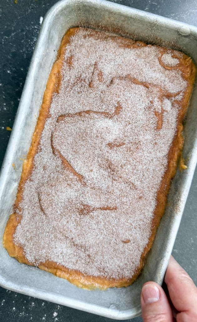 unbaked pumpkin bread in bread pan with cinnamon sugar sprinkled over the top