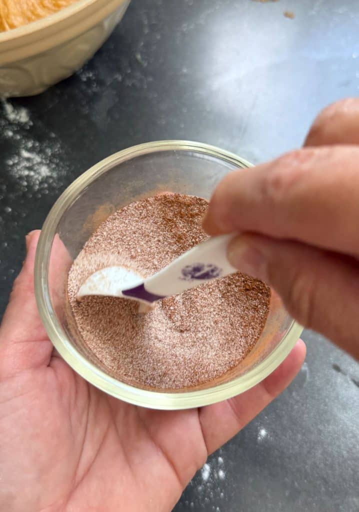 mixing sugar and cinnamon together in a small glass bowl