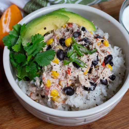 bowl of cream rotel chicken with black beans and green garnish