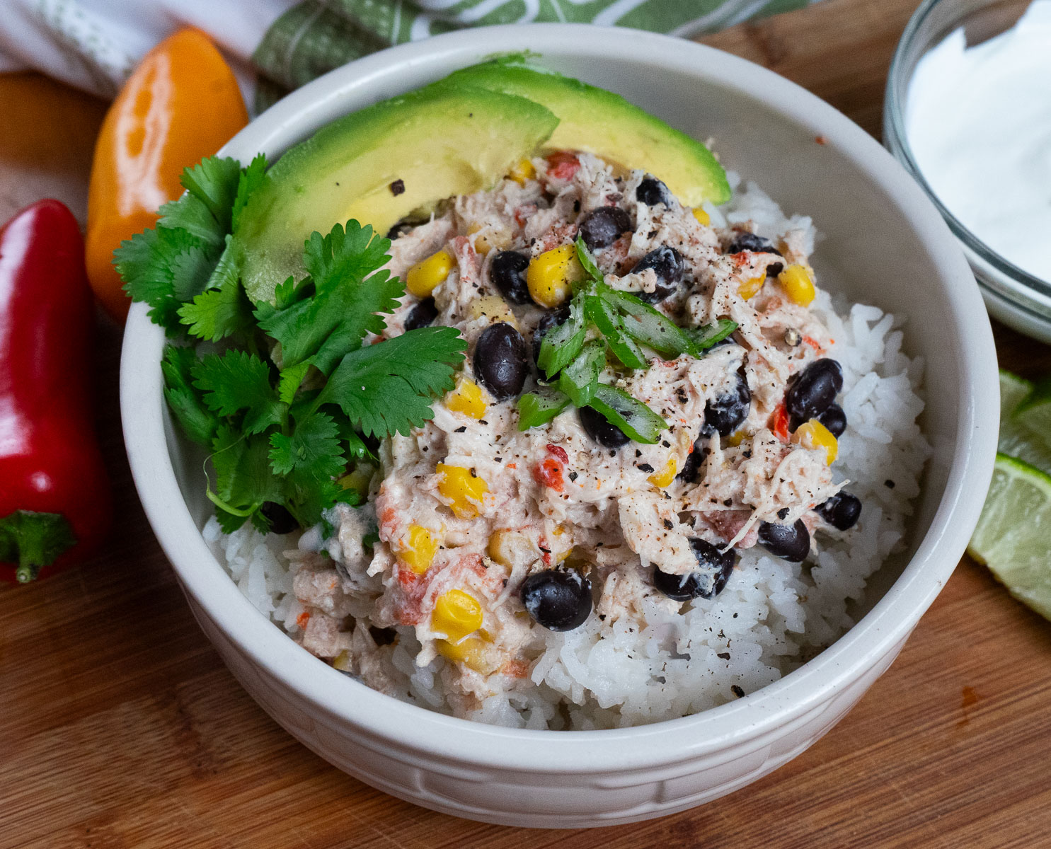 bowl of cream rotel chicken with black beans and green garnish