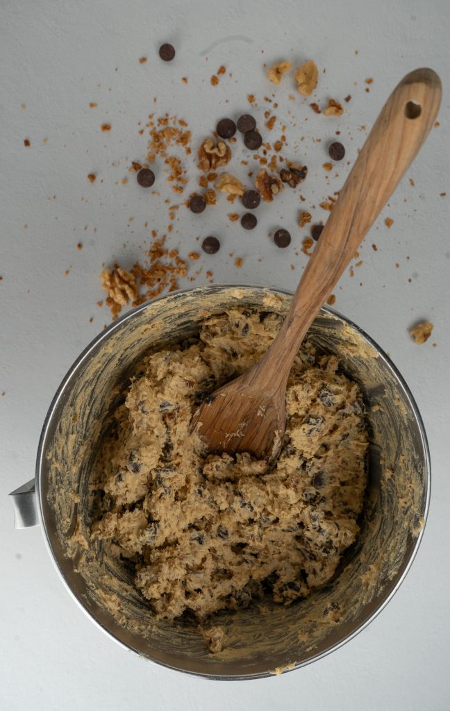 bowl of cookie dough with a wooden spoon mixing the ingredients
