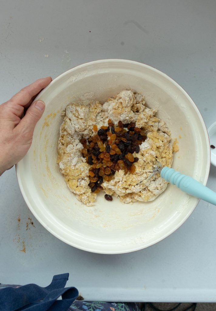 dough in bowl with raisins, about to be mixed in