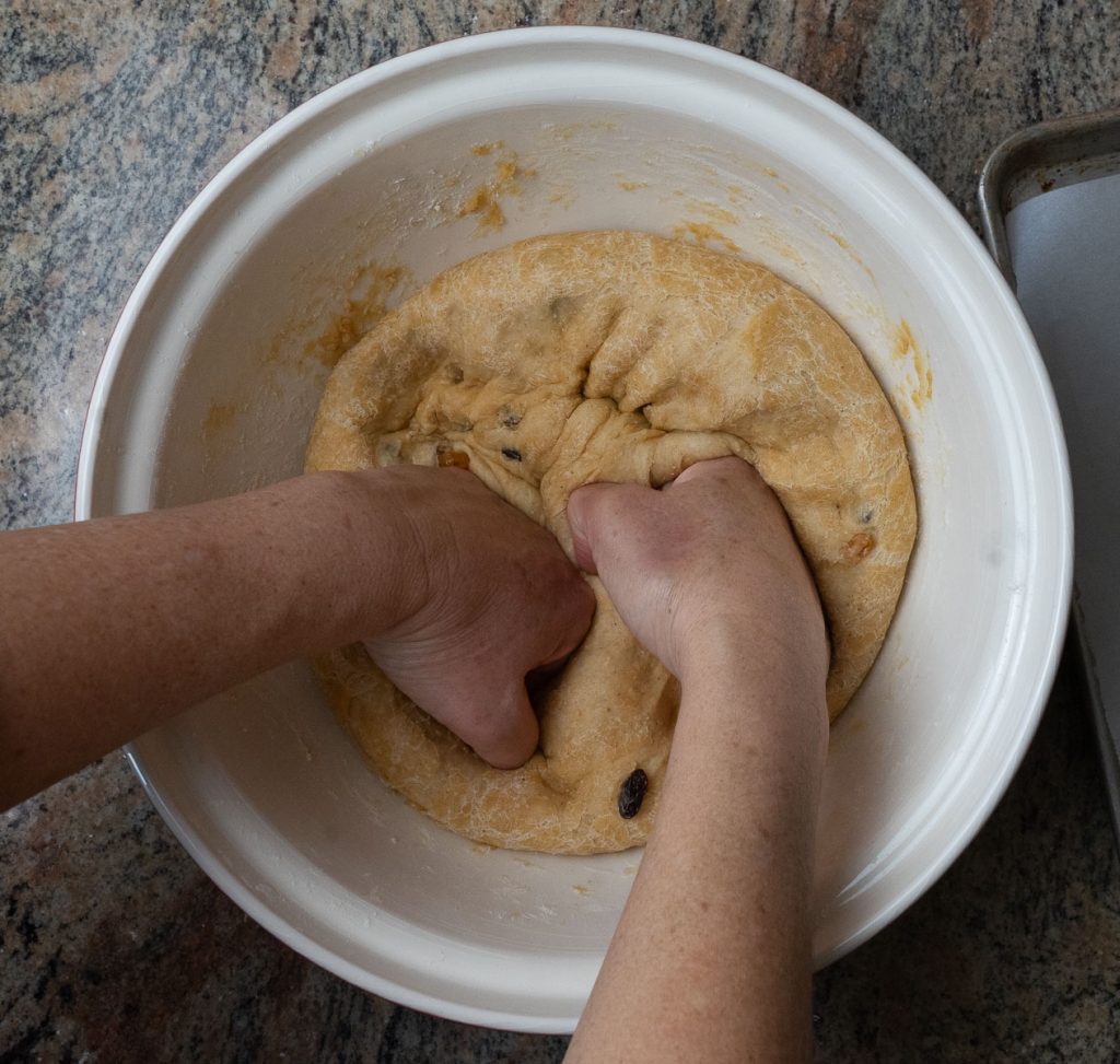 punching dough down in bowl