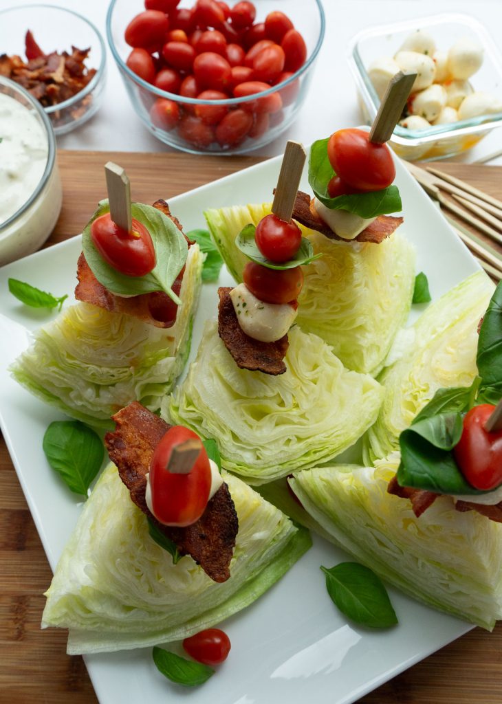 plated mini wedge salads with all the add ons in the background 