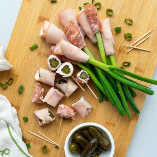 appetizer board ham wrapped green onions and gherkins