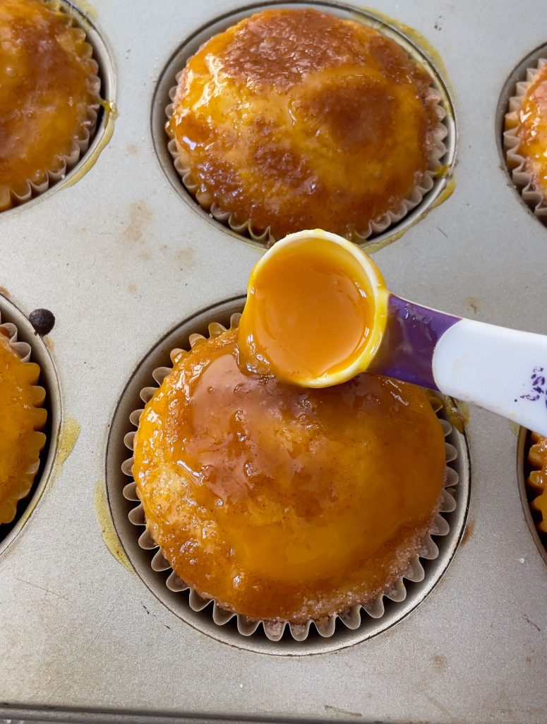 spooning oj reduction over muffin with a teaspoon