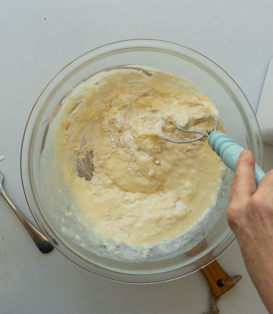 mixing wet and dry ingredients together in a glass bowl