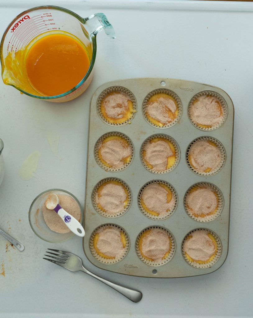 muffin with cinnamon sugar sprinkled on the top before going in the oven