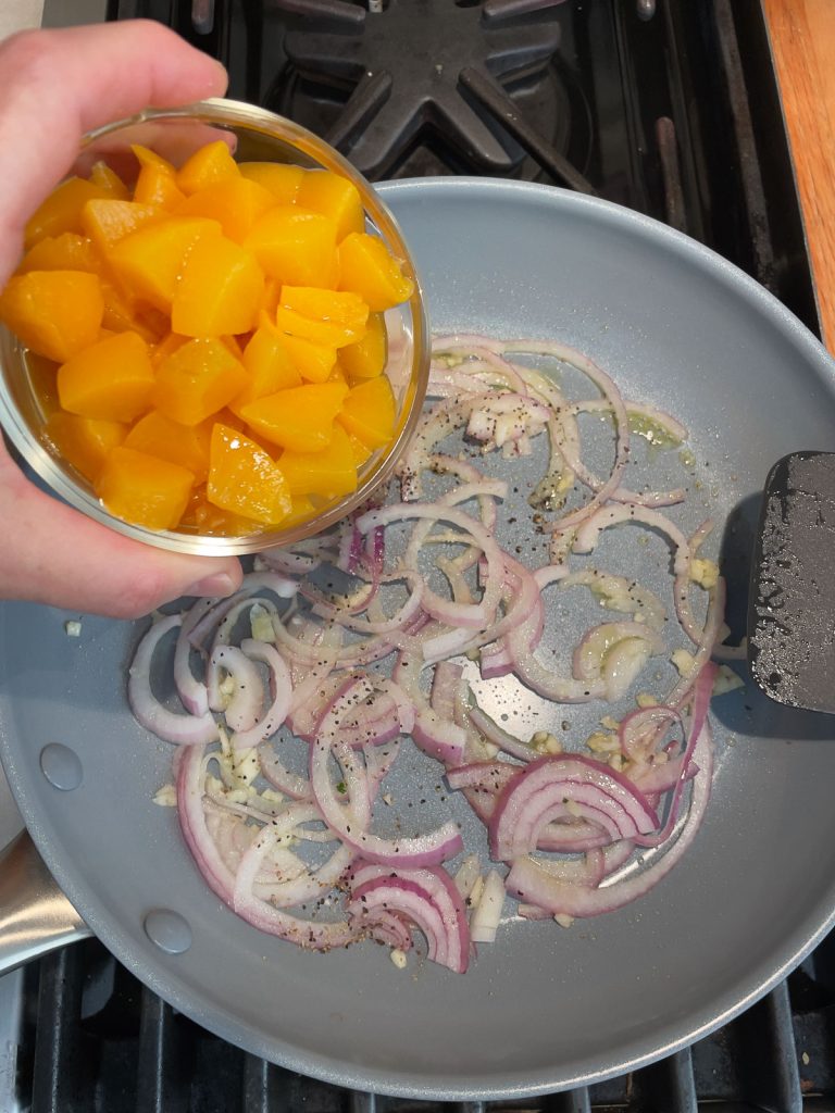 putting peaching into skillet with garlic and red onions