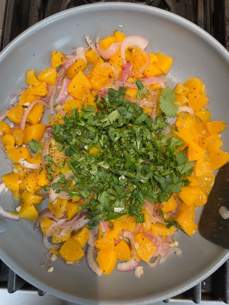 peaches, red onion, garlic sauteing, cilantro added on top