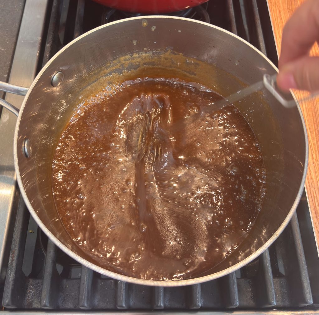 whisking caramel sauce in a sauce pan