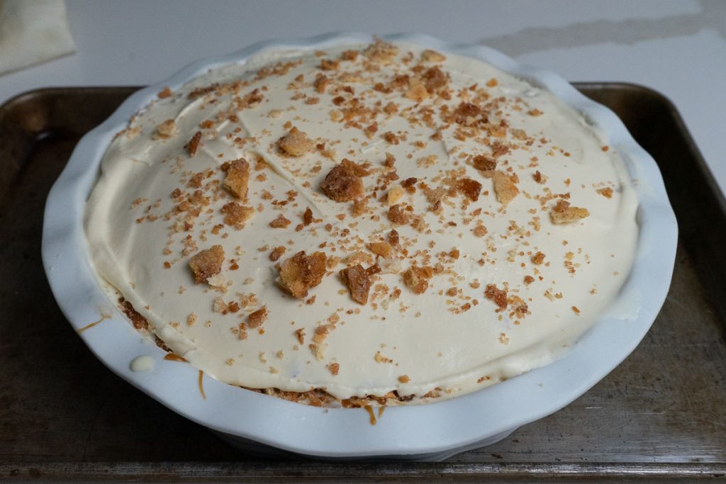 finished churro ice cream pie in a white pie plate on a dark countertop