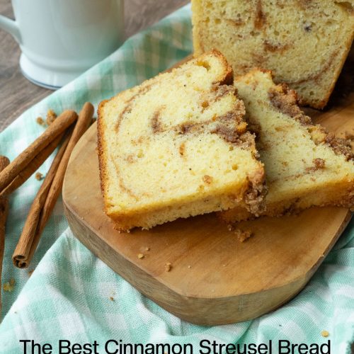 cinnamon streusel bread on a wood board with two slices laying in front of it with a cup of coffee in the upper left hand corner