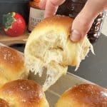 hand lifting a warm roll out of the baking pan