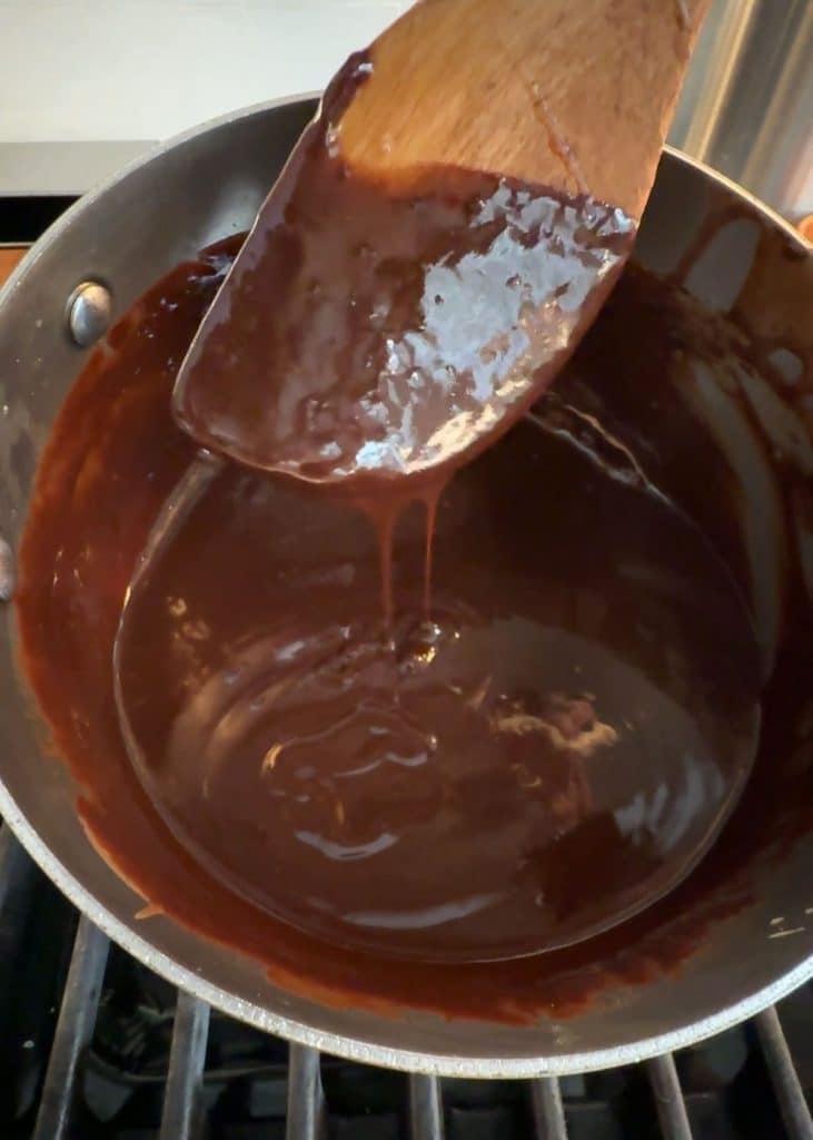 wooden spoon in sauce pan of hot fudge