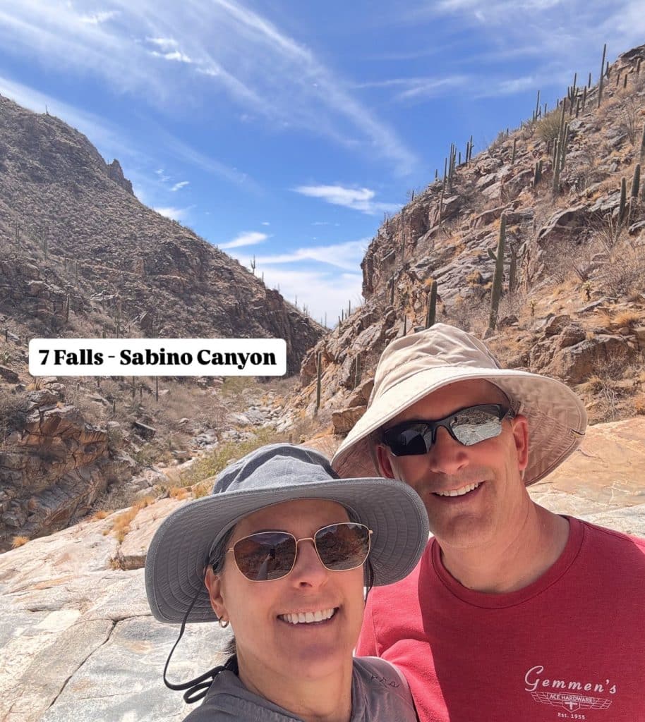 picture of two people with sunglasses and hats on with mountains in the back ground this is on seven falls trail in the sabino canyon recreational area tucson arizona