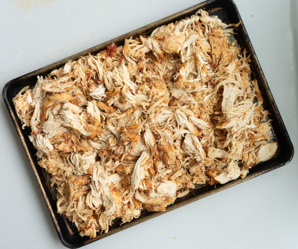 Pan of shredded mexican chicken on a white countertop