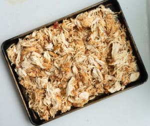 Pan of shredded mexican chicken on a white countertop