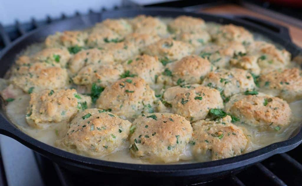 pan of southwest chicken and dumplings setting on stovetop in a cast iron skillet