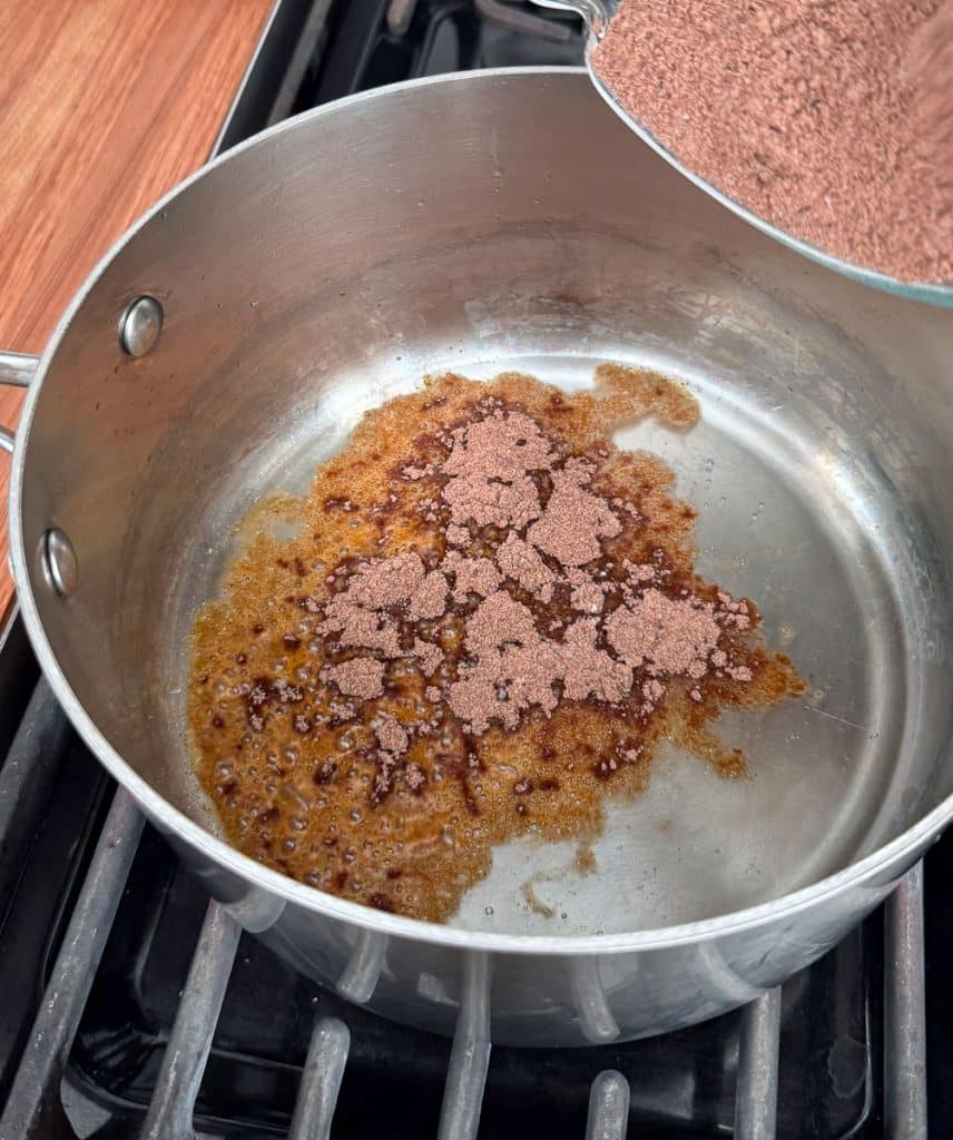 adding dry ingredients to a sauce pan with the warm vegetable oil