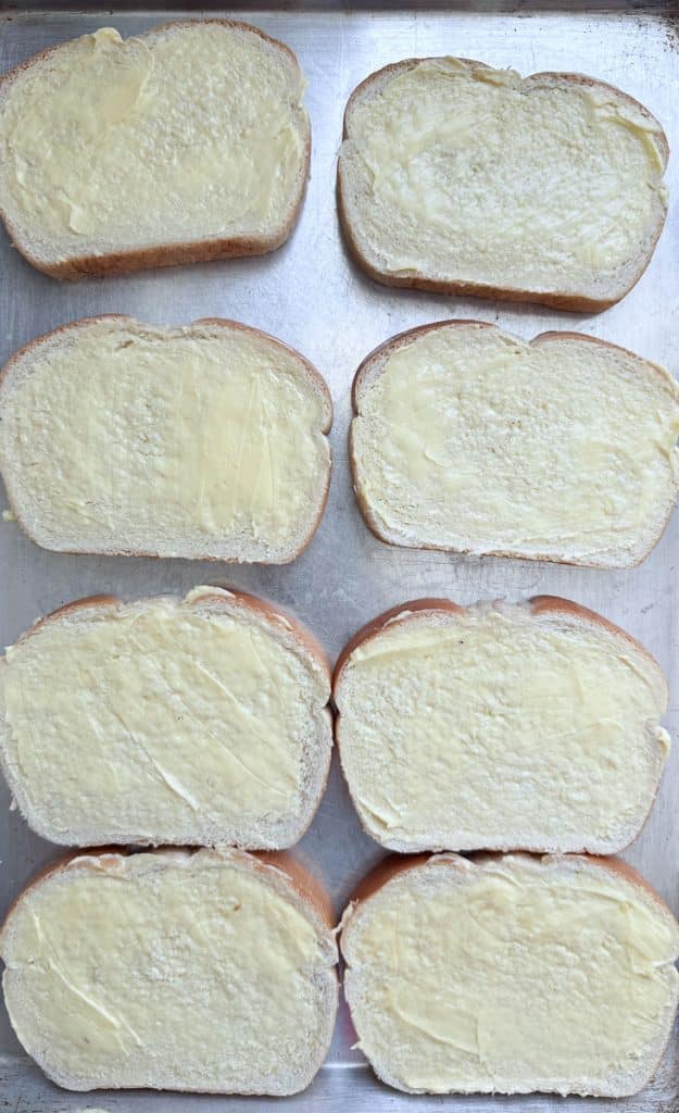 buttered slices of bread on a baking sheet